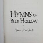 Page from a book showing a large serif title reading 'HYMN S OF' with the subtitle 'BLUE HOLLOW' and a small 'BY' line beneath, plus a handwritten signature near the bottom.